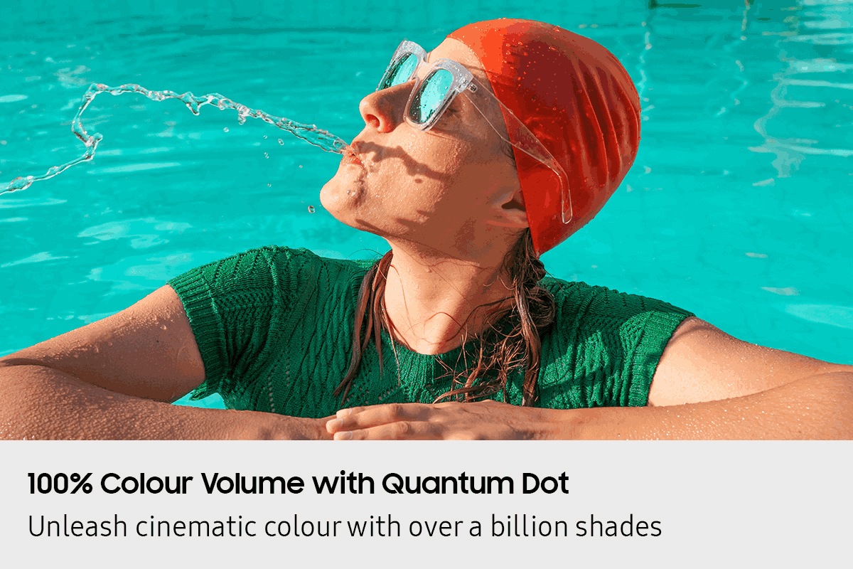 Scene of a woman in a pool spitting out water looks dull and washed out. TUV Rheinland Certified, Real Quantum Dot Display, www.tuv.com, ID 0217010367 logo. SGS Performance Tested No Cadmium (not detected) logo.