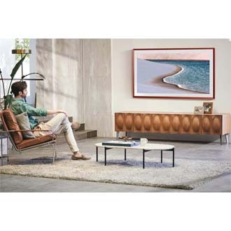 A man enjoys the ocean beach image on his living room the Frame TV.