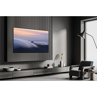 S90D wall-mounted in a contemporary living room, displaying a scene with clouds.