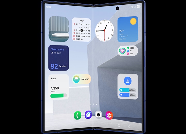Galaxy Z Fold7 is seen folded from the cover screen. Various widgets such as Photos, Sleep Score, Steps, Now Brief alert and Calendar are shown. The device transforms to unfold and is seen from the main screen because One UI 8 has been optimised to work seamlessly across both screens. More widgets can be seen including Weather, Clock, Health and Device care.