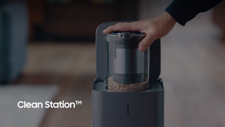 A hand putting Jet Stick dust bin into Clean Station