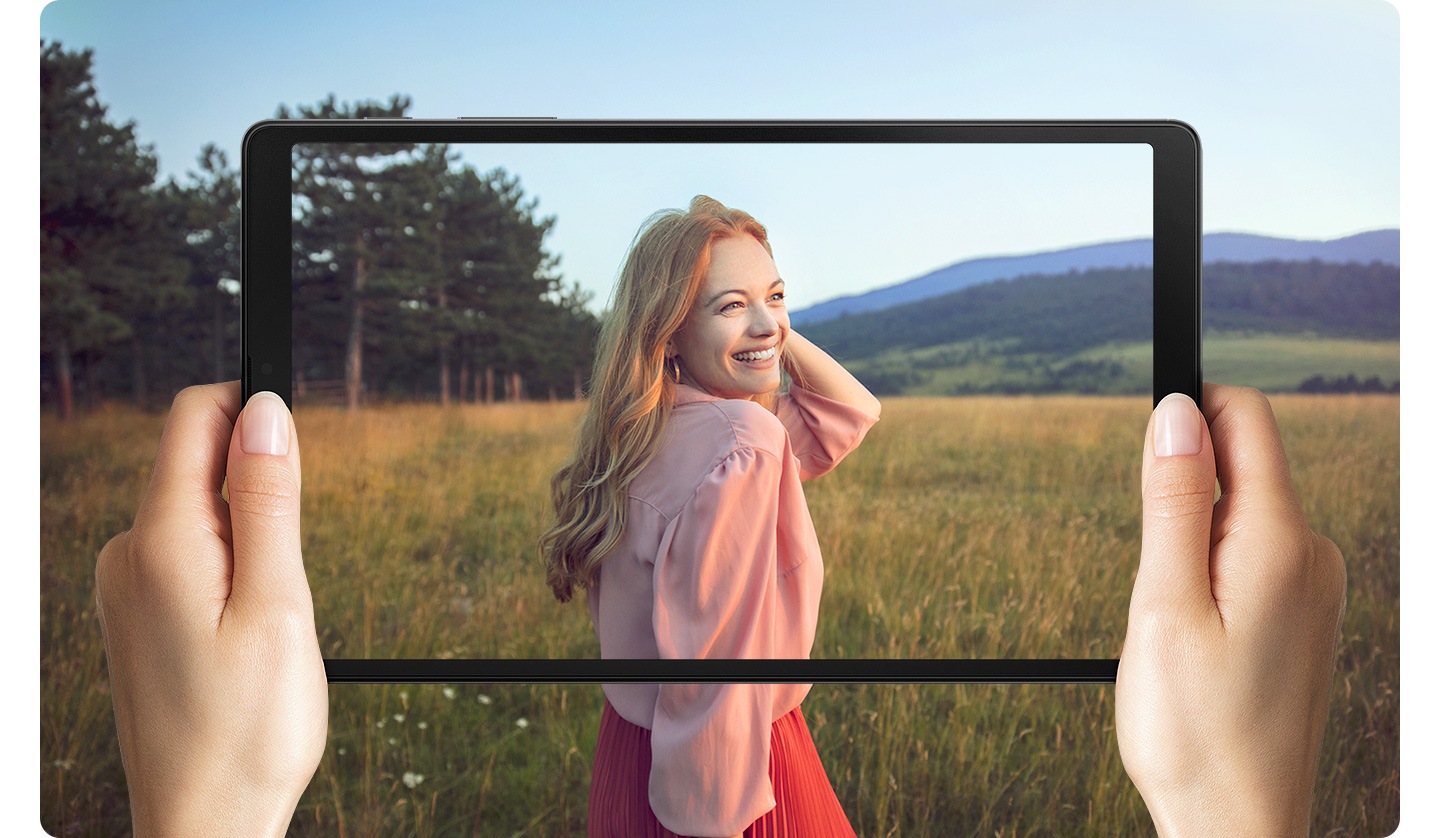 Sırt çantası geymiş, əlində bir yığın kağız və dərslik tutan adam. Qabağın ön hissəsində Galaxy Tab A7 Lite var.