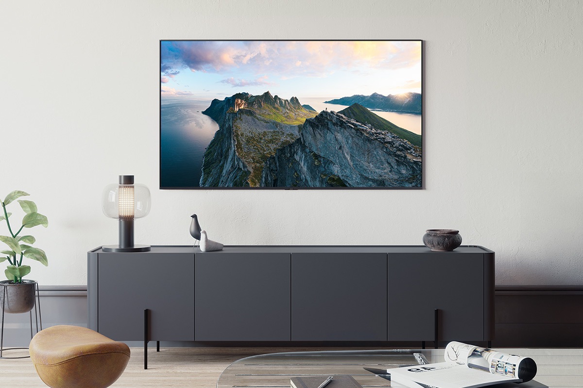 Müasir qonaq otağının divarına Neo QLED televizor quraşdırılıb. Ekranda dağların və suyun açıq hava mənzərələri göstərilir.