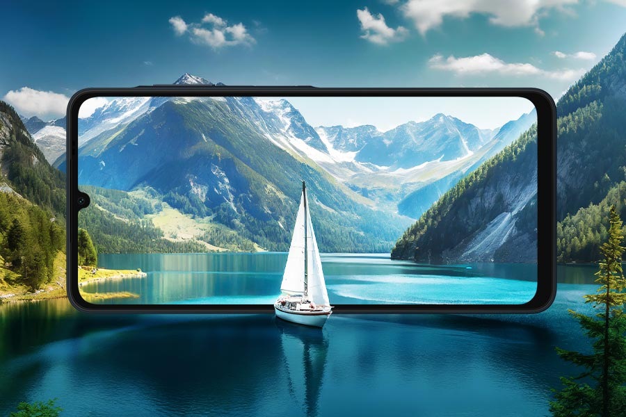 The Galaxy A06 screen blends into a scenic lake with mountains in the background and a sailboat in the foreground.