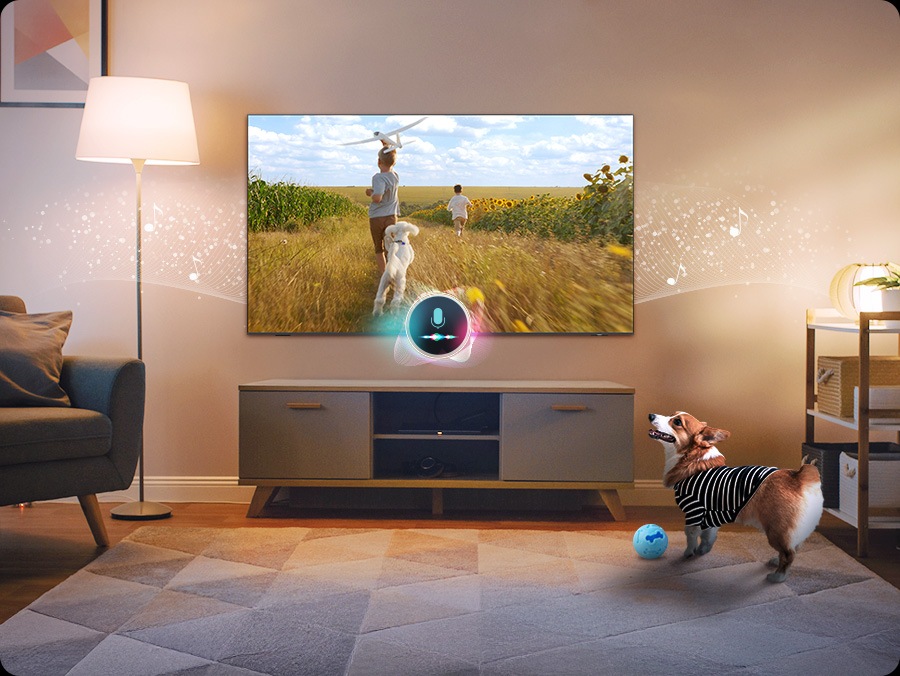 A dog barks in a living room. A microphone connected to the TV detects the noise. In response to the noise, the TV plays a scene of two boys and a puppy running along a sunflower field to soothe the barking dog.
