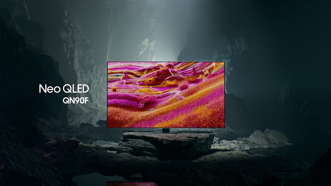 Samsung Neo QLED QN90F TV in een zwart-witte ondergrondse ruimte toont een kleurrijke scène van een buitenaards landschap.