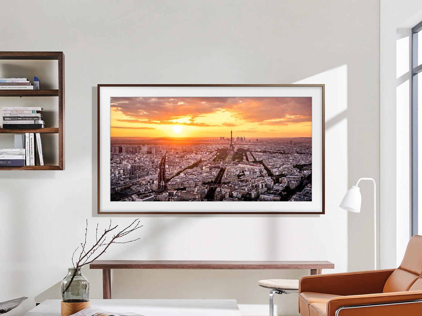 Het frame hangt aan de muur in een woonkamer met een zonsondergang boven een stad