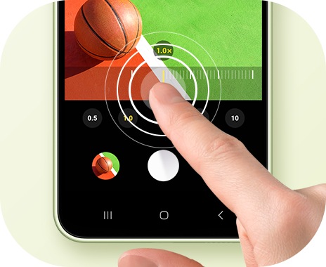 Una mano tocca sullo schermo di una Galaxy A34 5G, cambiando il rapporto zoom di una foto di un basket