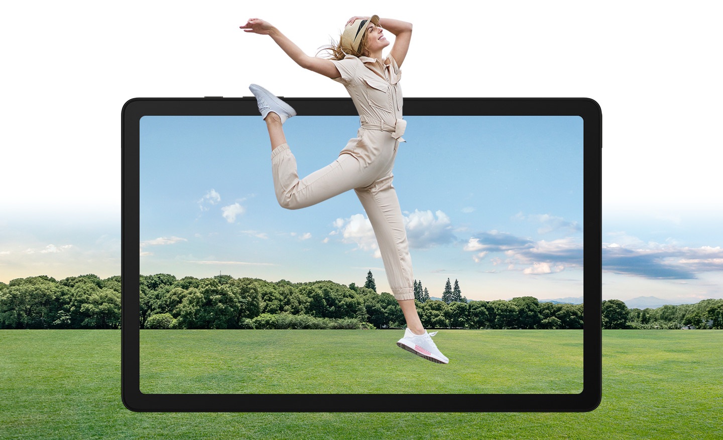 A woman can be seen jumping on an empty road surrounded by trees. The frame of Galaxy Tab A9+ can be seen behind her to illustrate the large and bright display of the device.