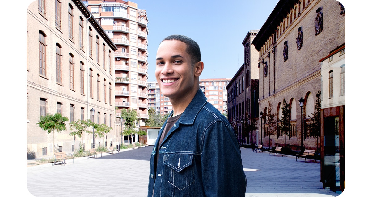 2. A man standing in a courtyard. He and the buildings in the background are equally clear.