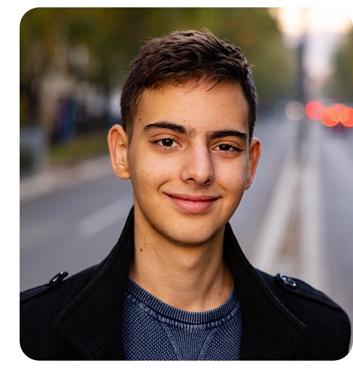 Um homem olhando para a câmera, tirando uma selfie. O fundo está sutilmente desfocado com o efeito bokeh.