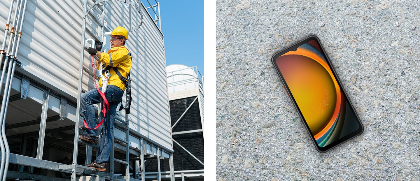 Um trabalhador da construção civil, trajando equipamentos de segurança, subindo uma escada em uma parede externa do edifício. Uma vista superior do Galaxy XCover7 colocada no solo de asfalto.