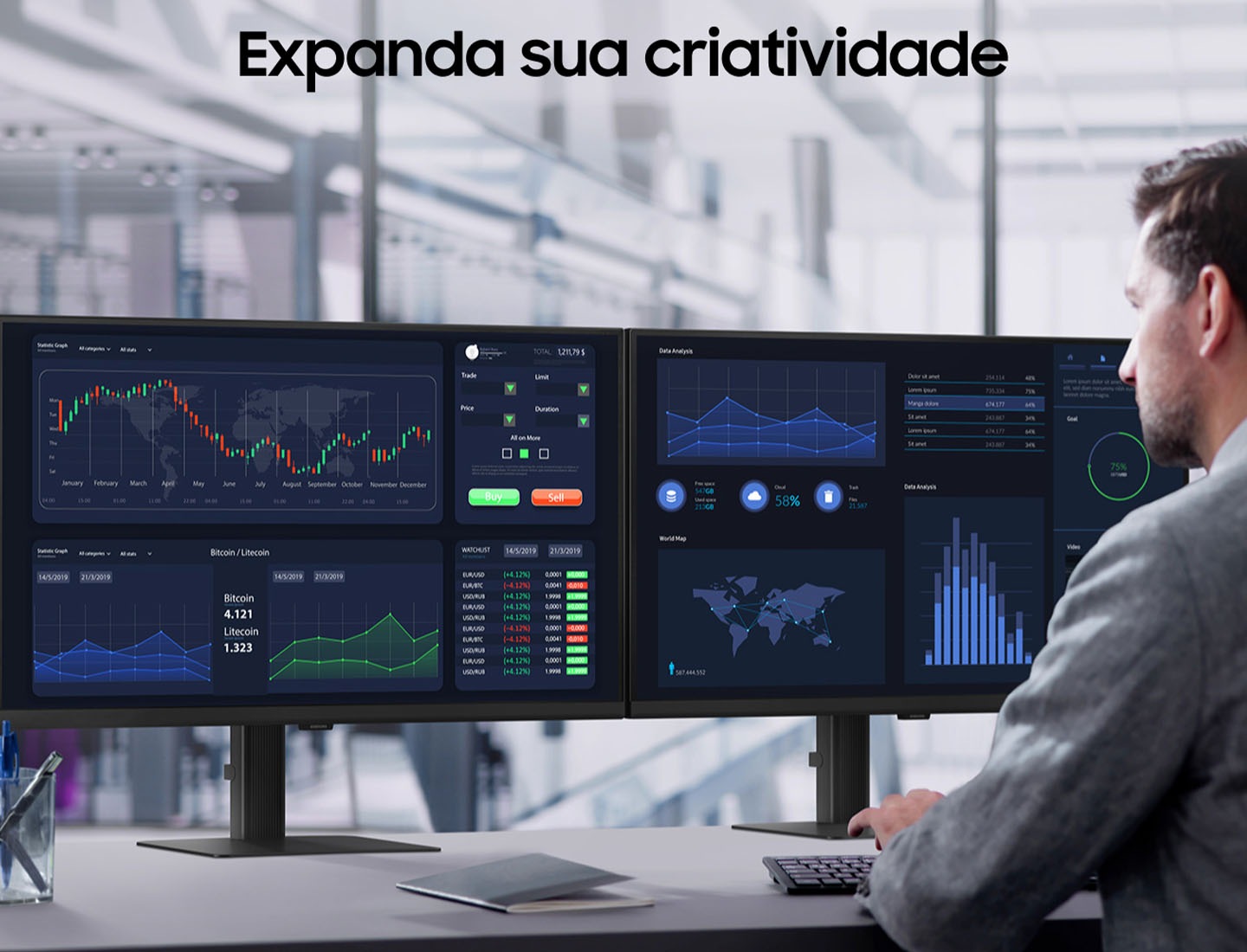 A man works at a desk, using a keyboard and two monitors side by side. The monitors show graphs and maps. Above him, text reads "Expand your creative realm".