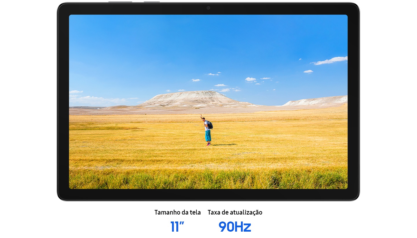 O Galaxy Tab A11+ está posicionado horizontalmente, exibindo uma imagem nítida de um homem acenando com as mãos, sugerindo um clima de liberdade. Ao fundo, um céu azul se estende sobre um amplo horizonte de grama amarela e marrom. O texto diz: Tamanho da tela 11,0 polegadas, taxa de atualização 90 Hz.