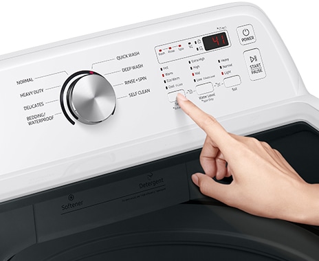 A person presses the button on the digital control panel to select the washing cycle and temperature.