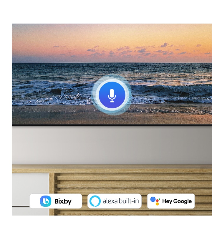 A microphone icon overlays a beach sunset TV screen image, demonstrating QLED TV voice assistant feature.