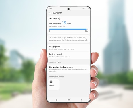 Shows a person holding a smartphone with the SmartThings App. On the screen is the Self Clean function, which shows how many cycles are left before the dishwasher needs to be cleaned.