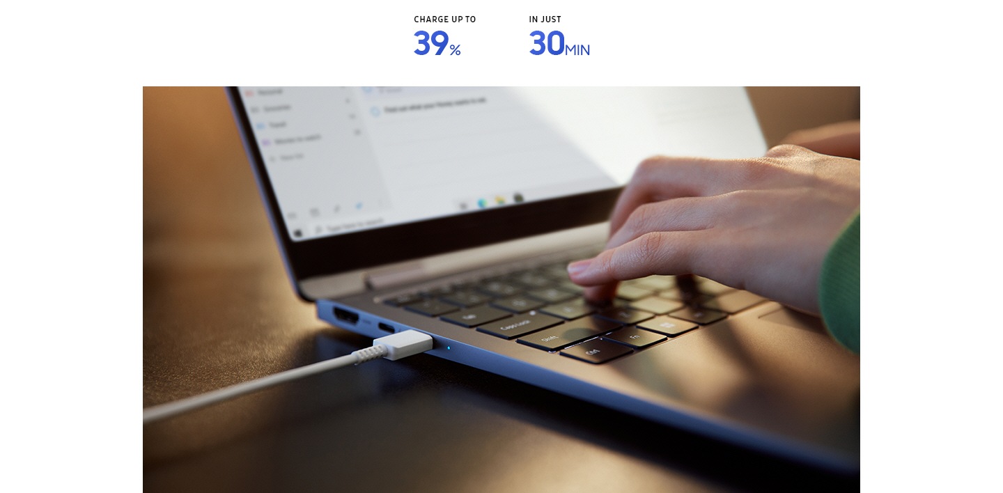 Close-up view of a person typing on the keyboard of Galaxy Book4 360 in Gray while the laptop is being charged using the inbox charger and data cable. CHARGE UP TO 39% IN JUST 30 MINUTES.