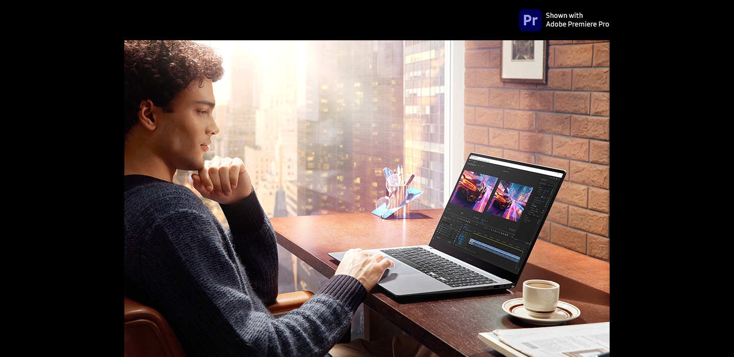 A young man is at a table in a brightly lit indoor area editing a colorful video using Adobe Premiere Pro app on Galaxy Book4 Ultra in Moonstone Gray. The onscreen image is clear and vibrant with improved visibility thanks to Vision Booster. Adobe Premiere Pro logo is shown.