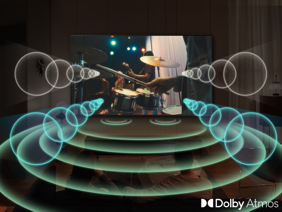 A Samsung TV plays a scene of a band performing, with a focus on the drummer. The TV emanates rings of sound in various sizes, which pulse energetically and travel in all directions to fill the space, indicating use of the Dolby Atmos feature.