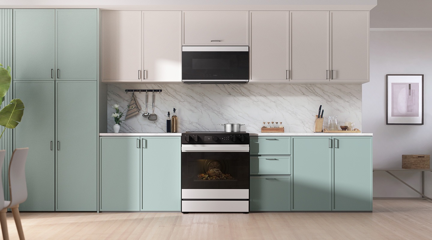 There is a radiant range installed in a kitchen with blue and white cabinets.