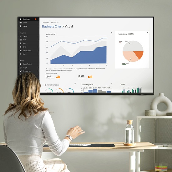 A woman uses her TV as her work screen as she works from home.