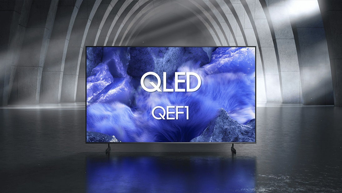 Samsung QLED QEF1 TV in a black and white indoor space displays a colourful scene of an otherworldly landscape.