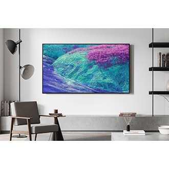 "A Neo QLED TV is installed on the wall of a modern space. The screen shows an abstract cliffside landscape in blue and purple tones. "