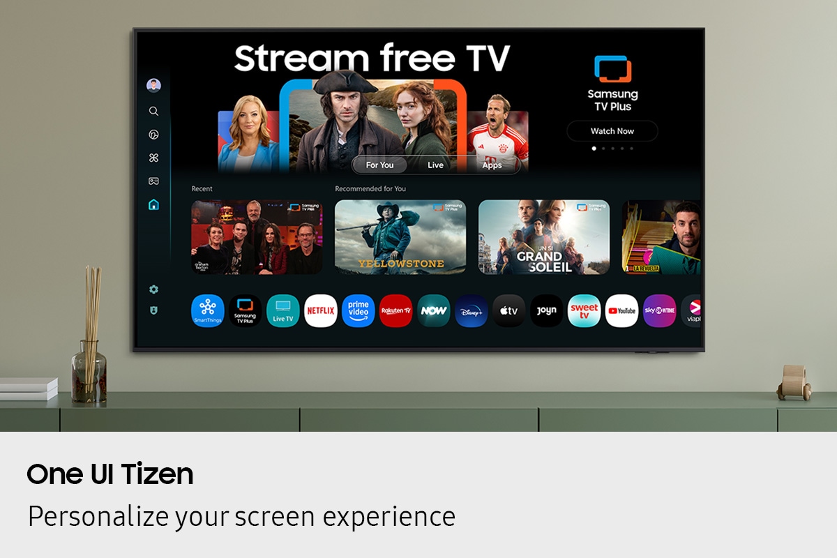 One UI Tizen’s home screen, with the various apps and services available, is displayed on a TV in a living room.