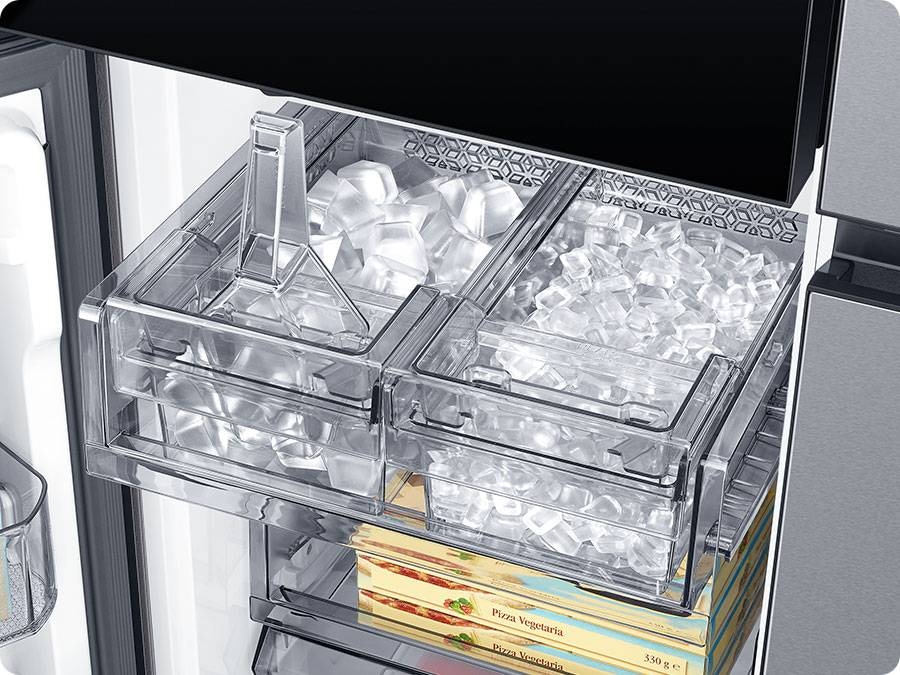 The dual tray in the freezer has ice. The left tray is full of cubed ice and the right tray has ice bites.