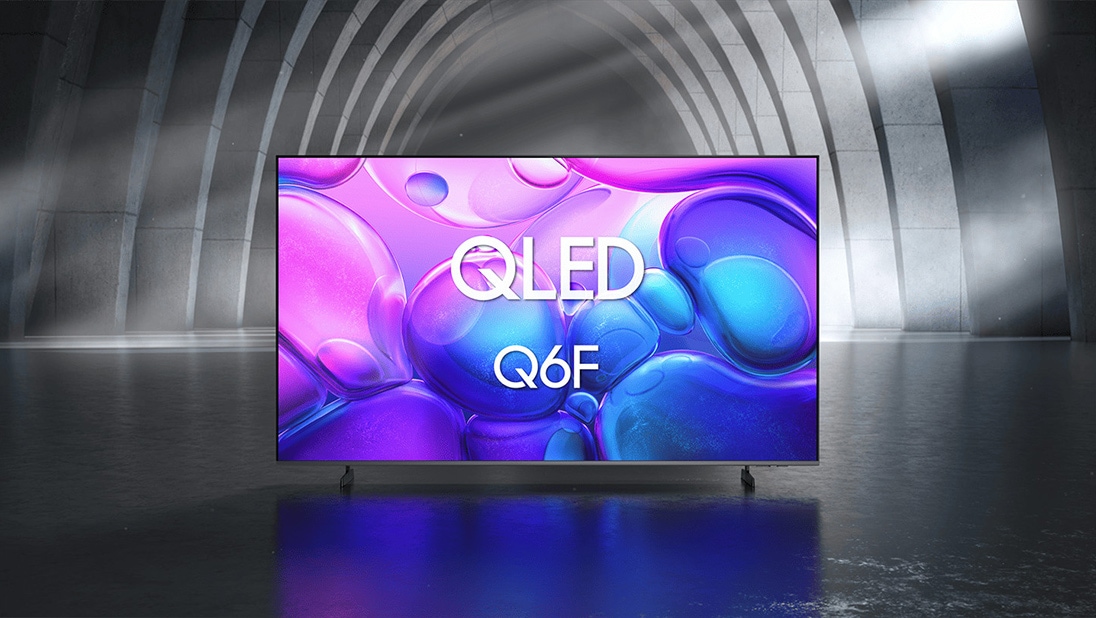 Samsung QLED Q6F TV in a black and white indoor space displays an abstract scene of purple bubbles. 