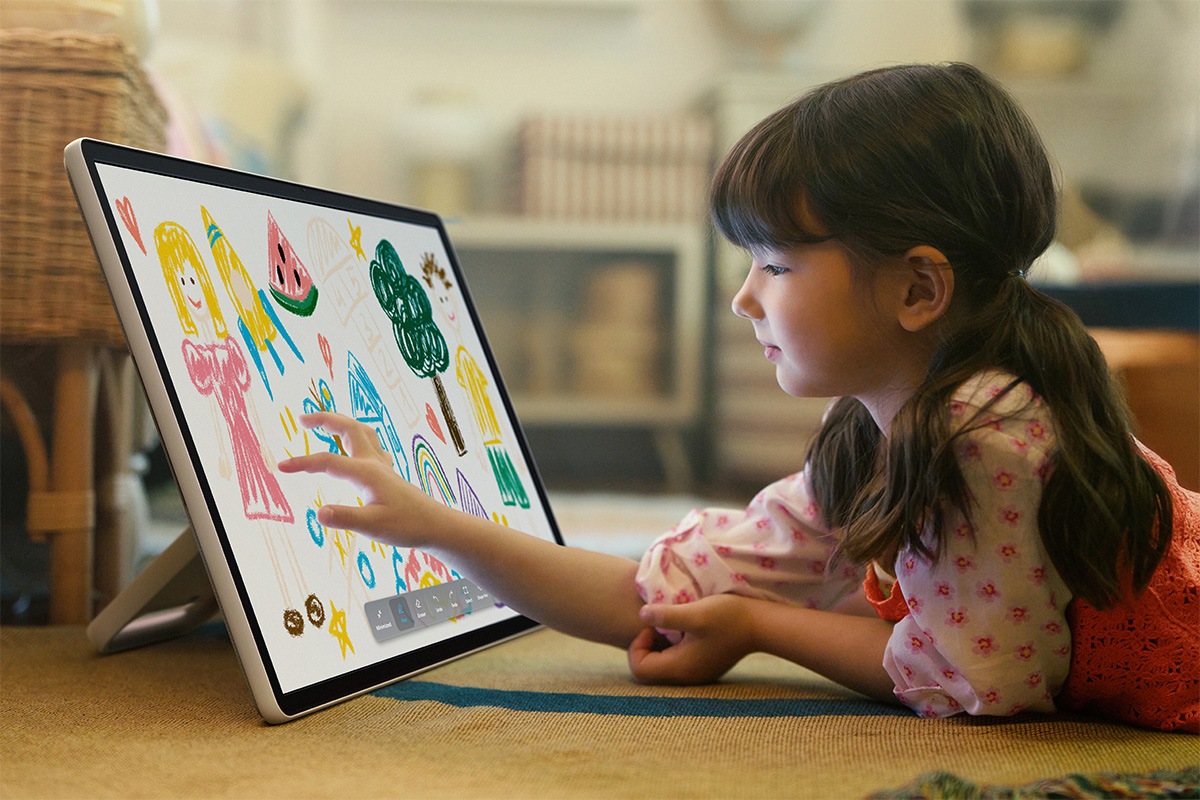 Une petite fille utilise ses doigts pour faire des dessins colorés sur The Movingstyle.