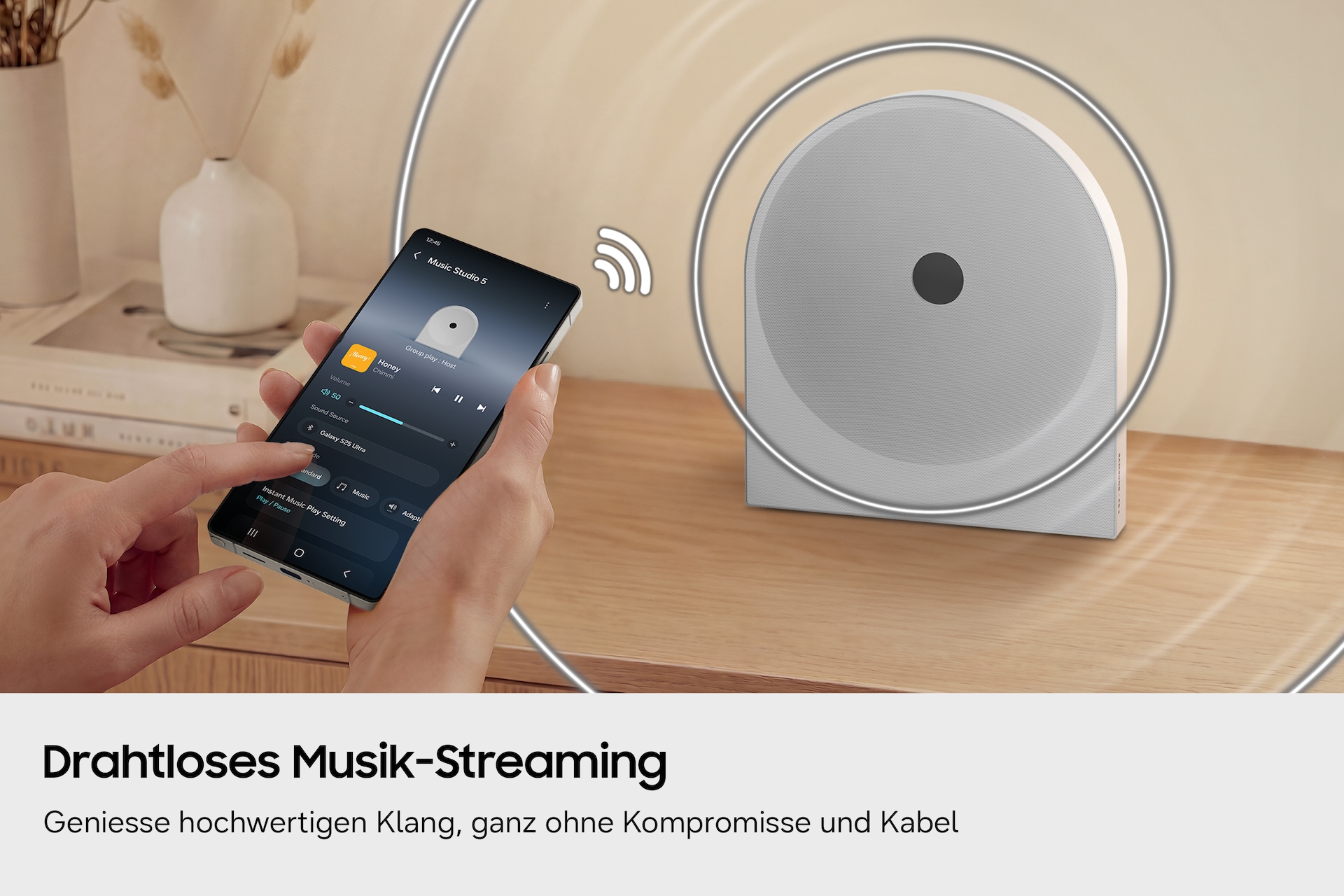 Eine Person nutzt ein Smartphone, um Musik kabellos auf den Music Studio 5 auf einem Holztisch zu streamen. 