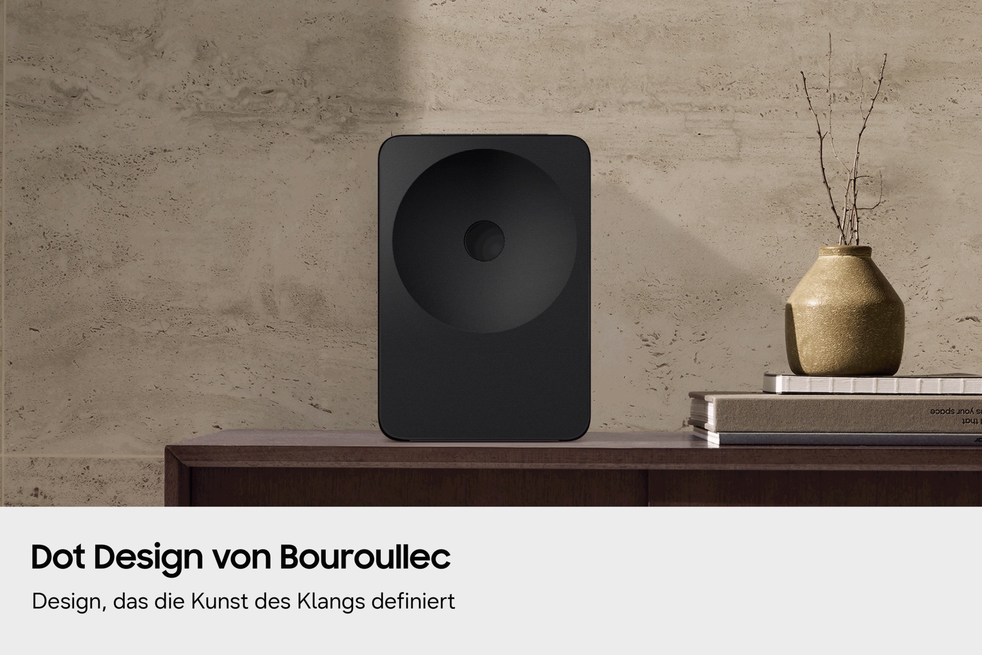 Ein Music Studio 7 steht auf einem Holztisch, dahinter eine strukturierte Wand. Eine goldene Vase und gestapelte Bücher verleihen dem Ganzen eine moderne, elegante Note.