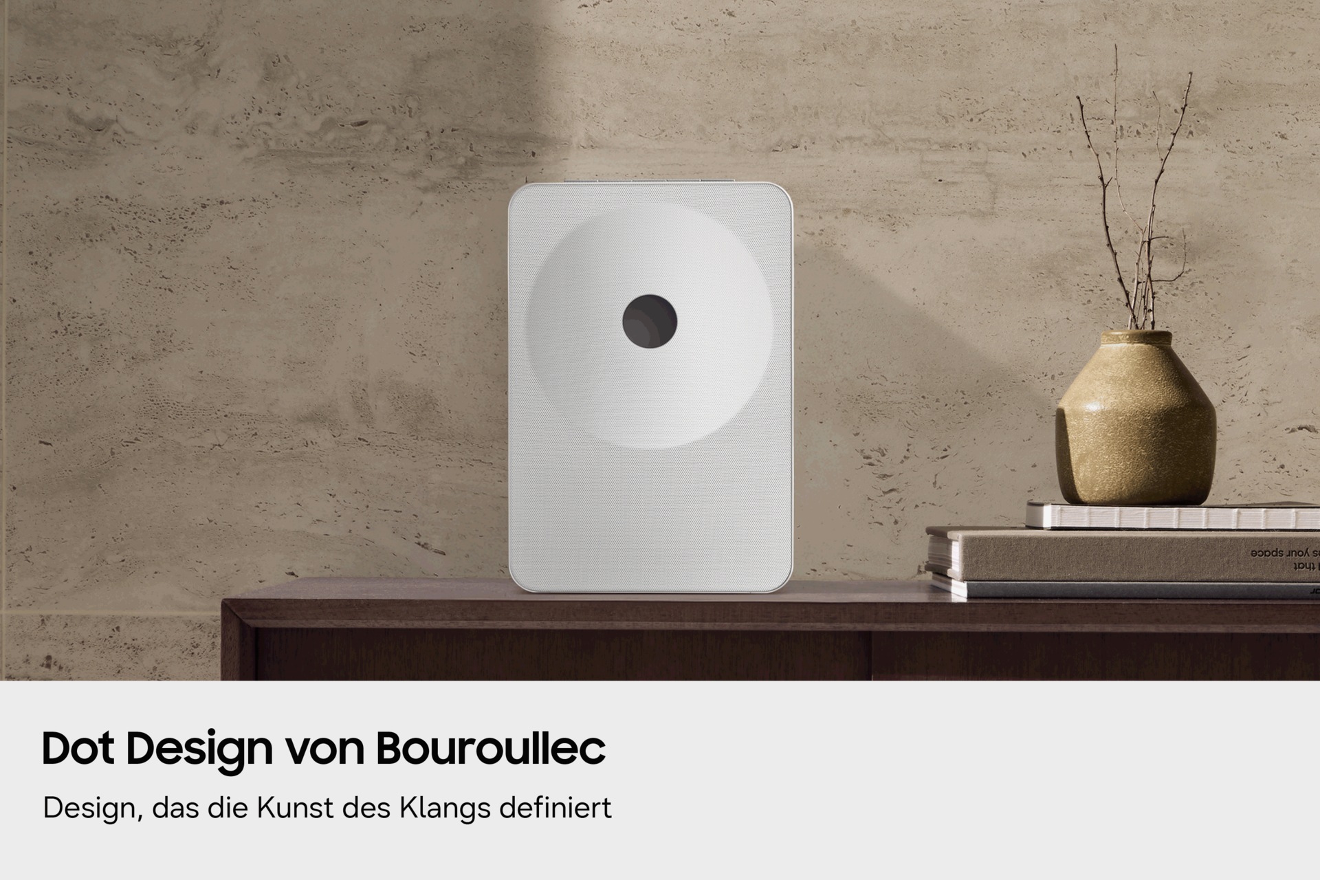 Ein Music Studio 7 steht auf einem Holztisch, dahinter eine strukturierte Wand. Eine goldene Vase und gestapelte Bücher verleihen dem Ganzen eine moderne, elegante Note.