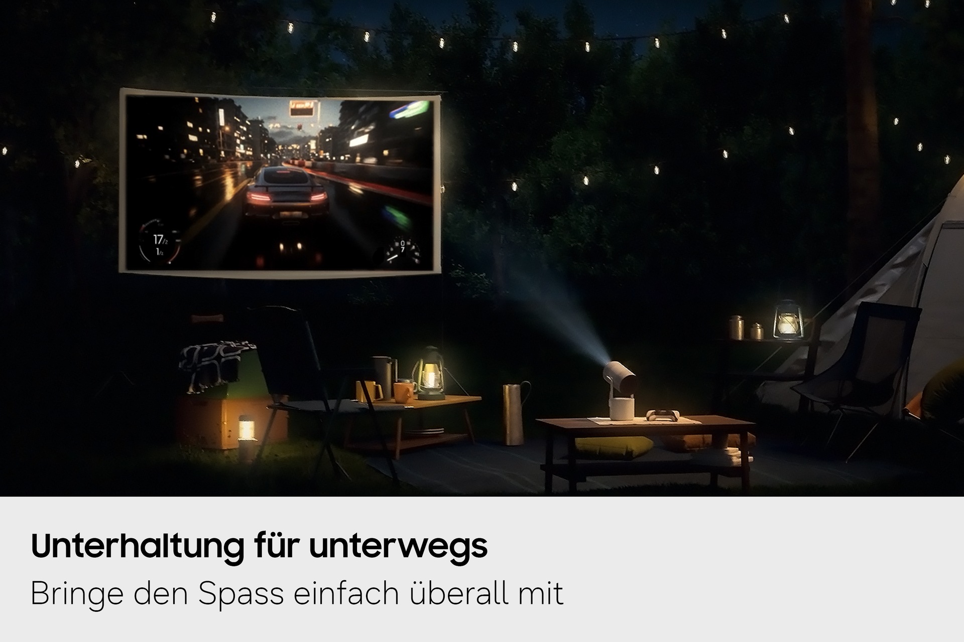 Samsung The Freestyle+ projiziert nachts auf einem Campingplatz im Freien eine Gaming-Szene auf eine Leinwand und demonstriert damit seine Einsatzmöglichkeiten an verschiedenen Orten.