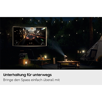 Samsung The Freestyle+ projiziert nachts auf einem Campingplatz im Freien eine Gaming-Szene auf eine Leinwand und demonstriert damit seine Einsatzmöglichkeiten an verschiedenen Orten.