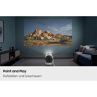 Das Samsung The Freestyle+ projiziert im Wohnzimmer ein Landschaftsbild gestochen scharf auf strukturierte Vorhänge und demonstriert damit seine Fähigkeit, effektiv auf verschiedene Oberflächen zu projizieren.
