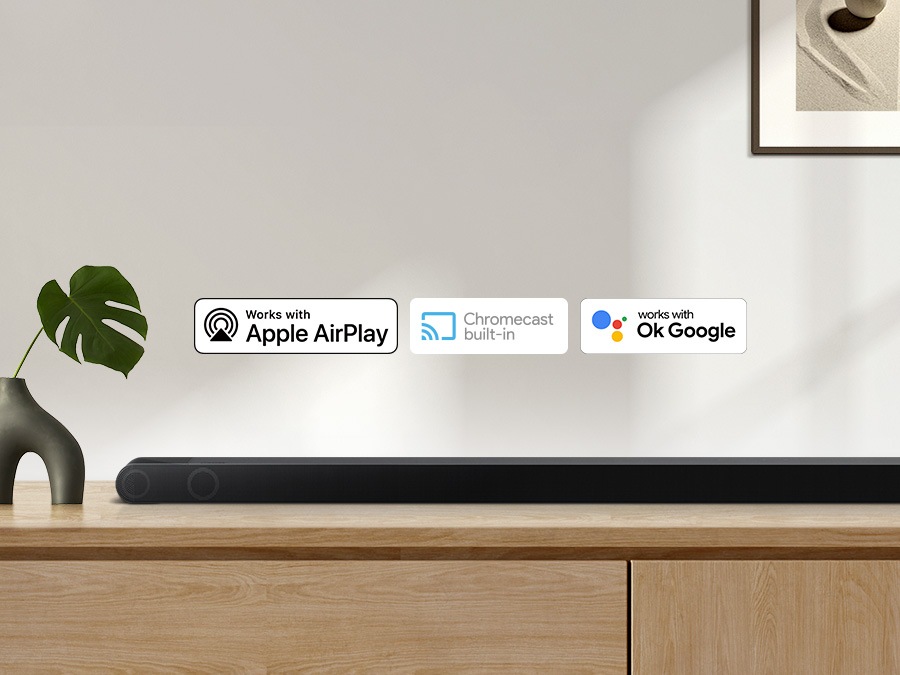 Apple Airplay logosu, Chromecast yerleşik logosu ve OK Google logosu, oturma odası dolabında oturan Samsung S800B ses çubuğu ile birlikte olabilir