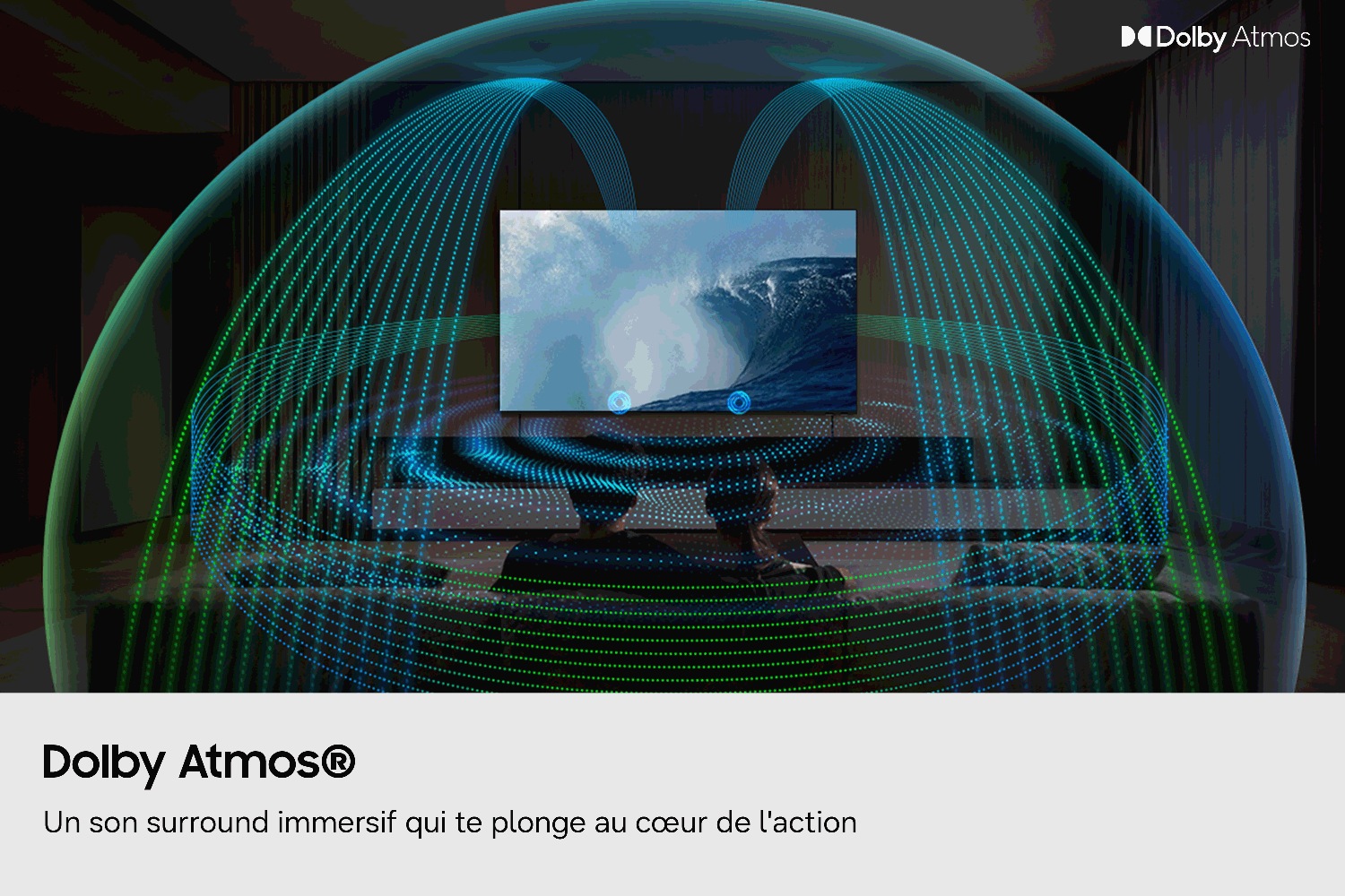 Sur un écran de télévision, on voit une immense vague, encadrée par une coupole illustrée composée d'ondes sonores bleues et vertes qui symbolisent le son Dolby Atmos ; deux personnes sont assises devant.