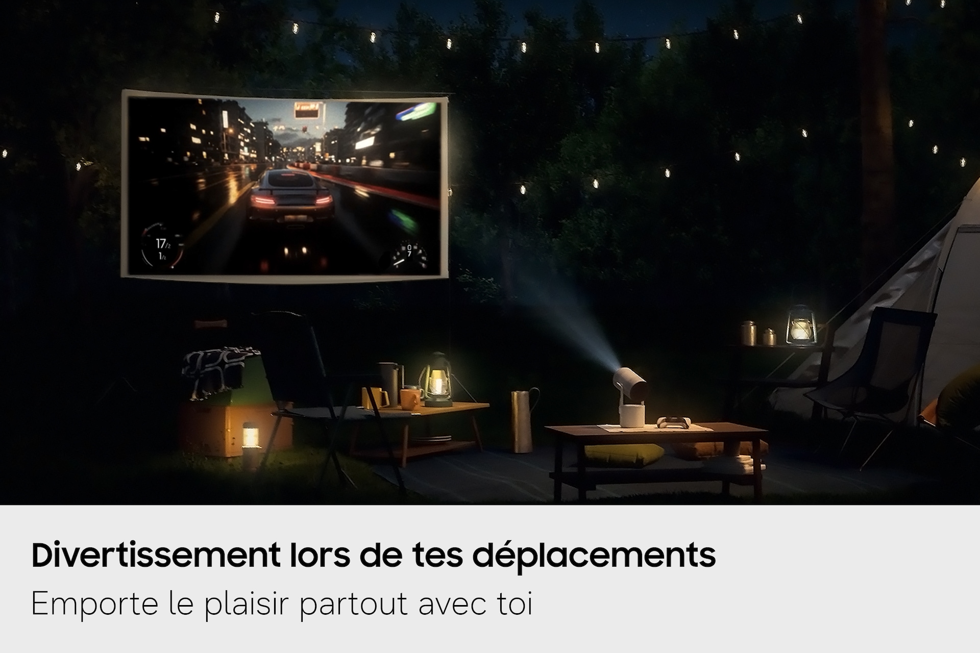 Samsung The Freestyle+ projette de nuit, en plein air sur un terrain de camping, une scène de jeu vidéo sur un écran, démontrant ainsi ses possibilités d'utilisation dans différents lieux.
