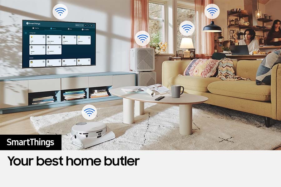 The SmartThings UI is on display on the TV. Wi-Fi icons are floating on top of the TV, vacuum robot, air purifie and lights.