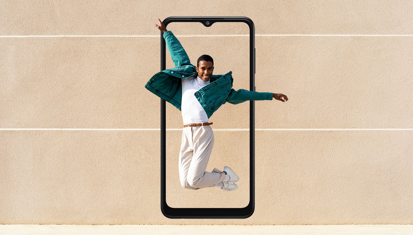 The outline of a Galaxy A04 is set in portrait mode in front of a sports field background with 2 white lines. Onscreen is a man in a jump pose, with his hands and part of his green jacket extending beyond the frame.