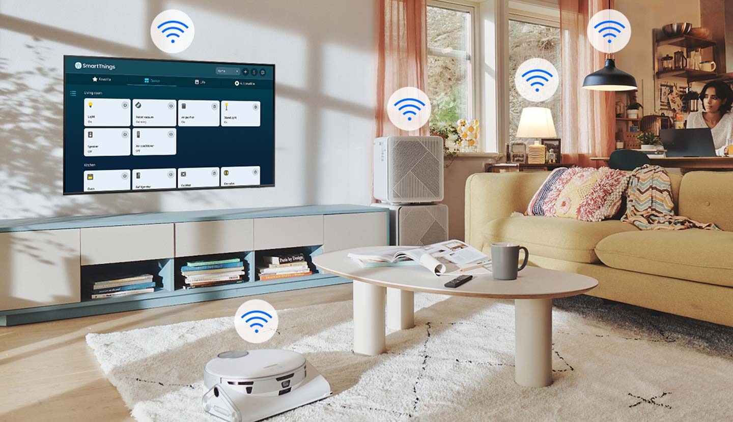 La interfaz de SmartThings se muestra en el televisor. Los iconos Wi-Fi flotan sobre el televisor, el robot aspirador, el purificador de aire y las luces.