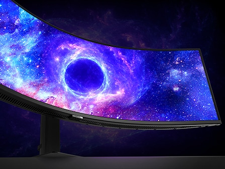 Se muestra un monitor Odyssey parado sobre una superficie contra un fondo negro. En la pantalla hay una escena de galaxia espacial con un círculo azul brillante en el centro.