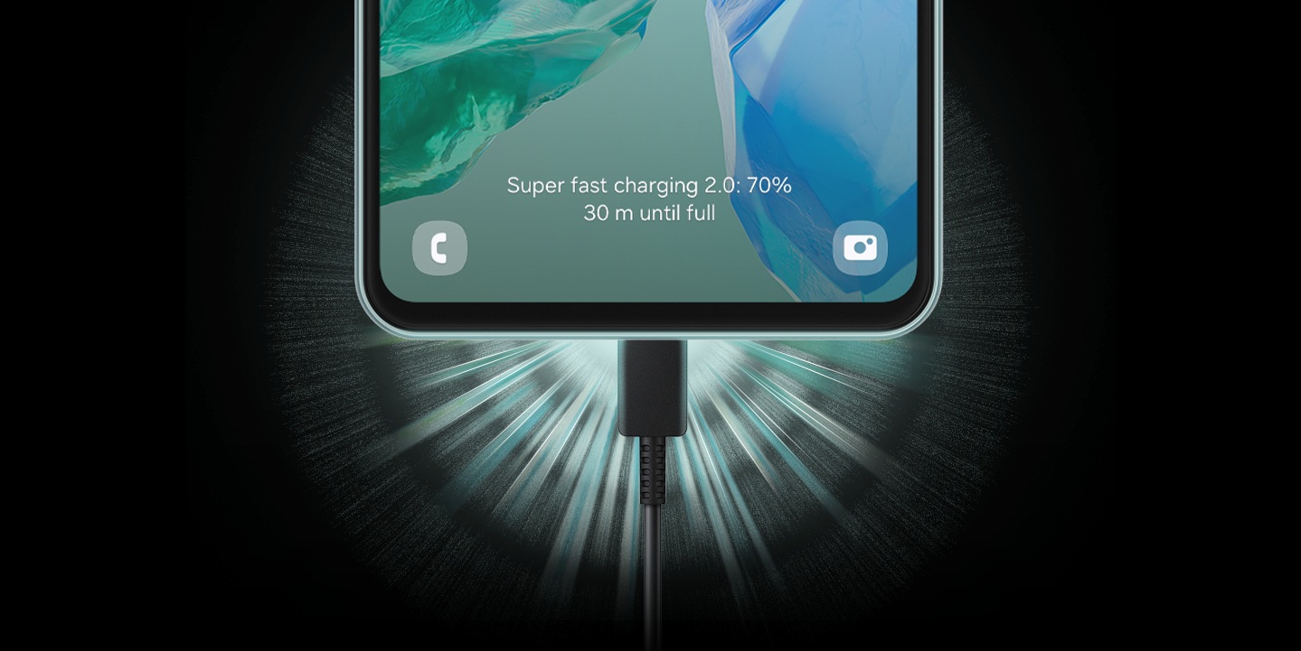 Se muestra el tercio inferior de un dispositivo Galaxy M55 5G con el cable de carga conectado. El texto en pantalla dice: 'Carga superrápida 2.0: 70%. 30 m hasta carga completa'.