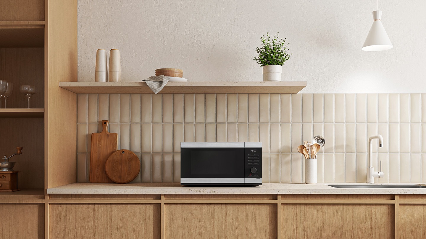 Shows the microwave oven on the counter top of a modern kitchen.