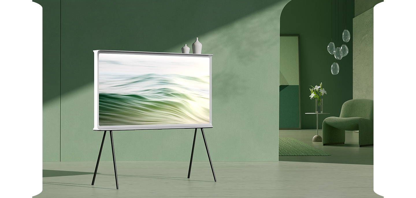 El televisor Serif está montado sobre un soporte en un espacio interior decorado en tonos verdes. El Serif muestra ondas verdes en la pantalla.