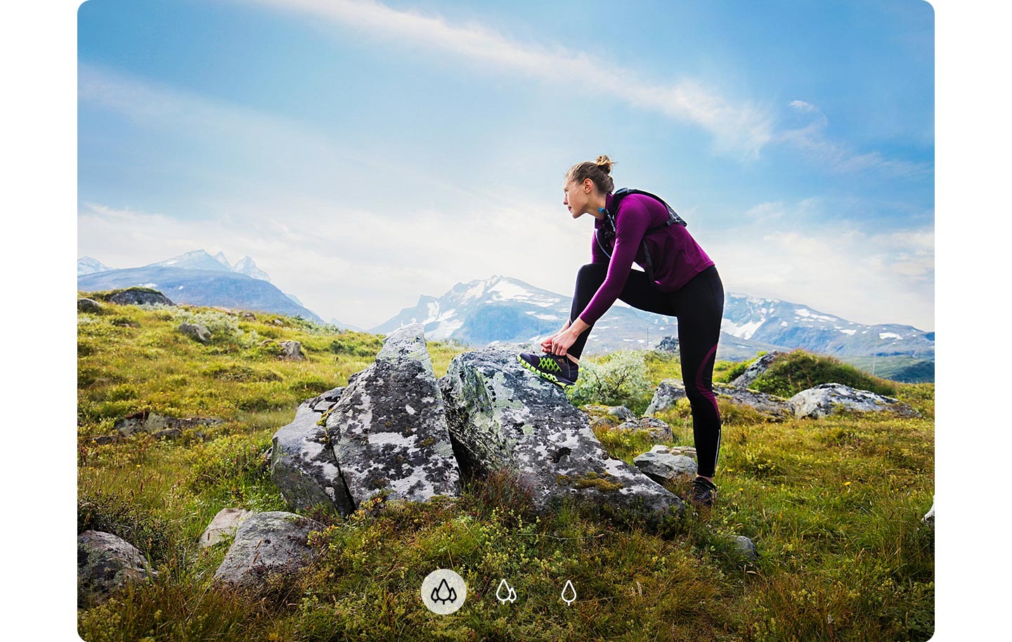 Una mujer mirando a lo lejos con un pie sobre una roca y montañas de fondo, lo que indica que el A72 puede capturar una imagen más amplia con la cámara ultraancha.