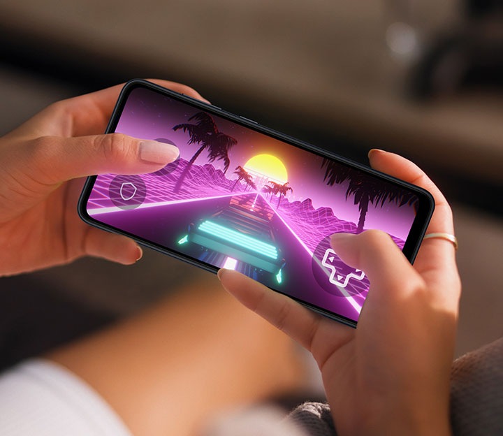 Dos manos sosteniendo un Galaxy A05 muestran un juego de carreras en pantalla.